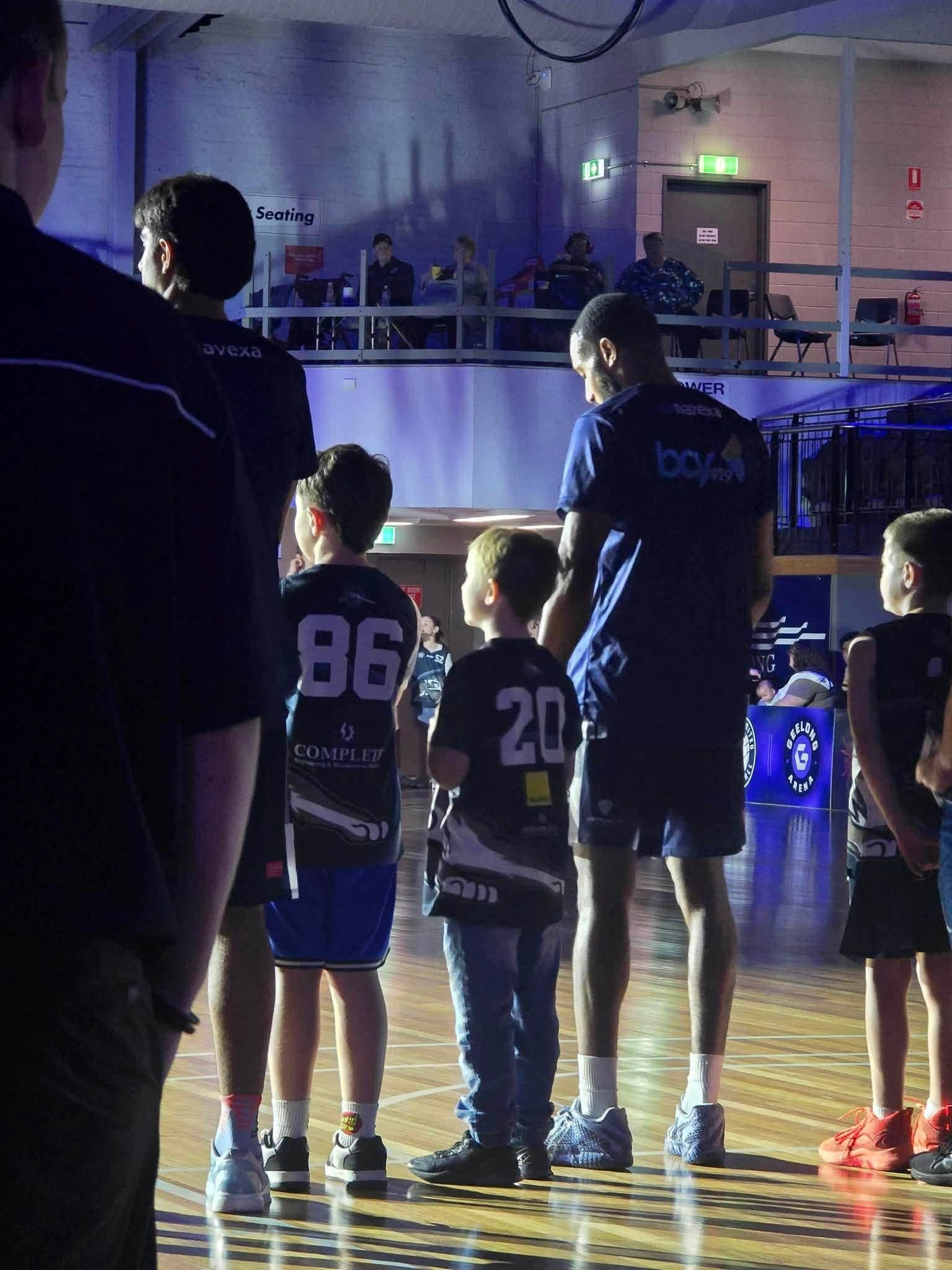 Bobcats juniors walking out beside the players before a game